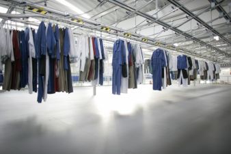 A modern conveying and sorting system arranges the loading of a washing machine according to customer and wearer