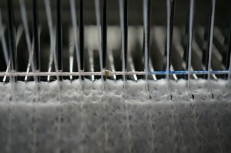 Large-scale incorporation of a functionalised E-thread (photo: with LEDs) on a non-woven Raschel machine type RS3 MSUS-V Photo: STFI